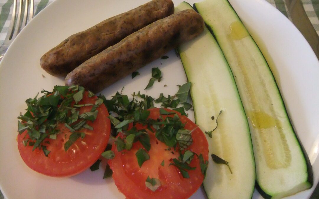 Baked herby sausages with courgette and tomato